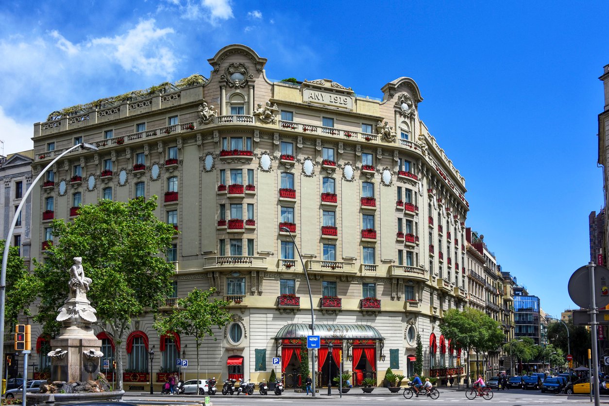 Elegant historic building with a classic facade featuring red window accents and ornate architectural details, located in the heart of Barcelona.