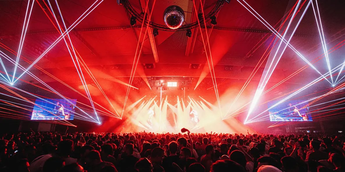 Crowd enjoying an indoor concert with vibrant red laser lights at Sonar Festival in Barcelona.