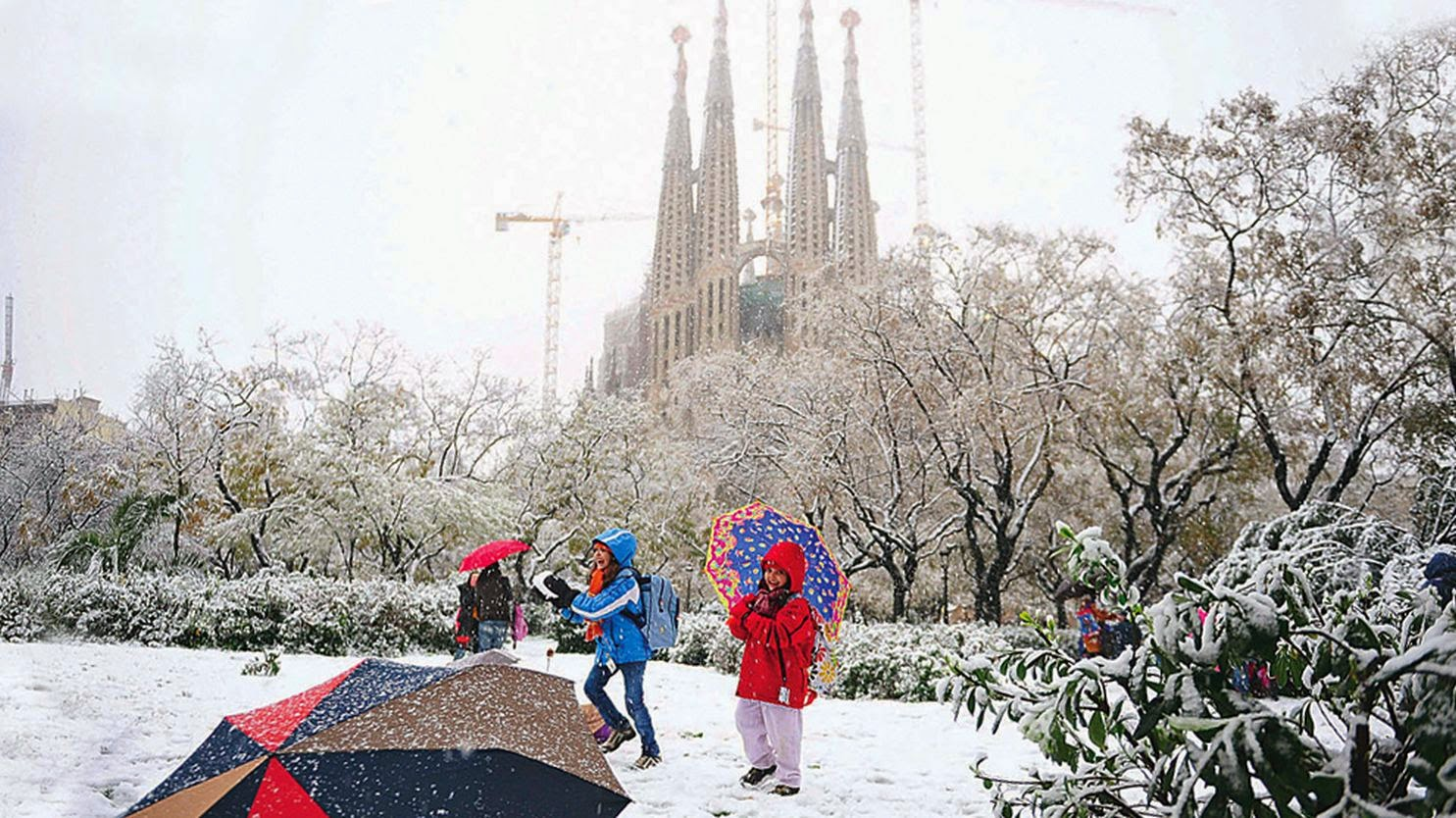 Children playing in the snow near La Sagrada Familia in Barcelona during a rare winter snowfall.